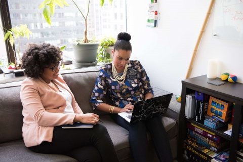 Photo of two African American women looking at a laptop